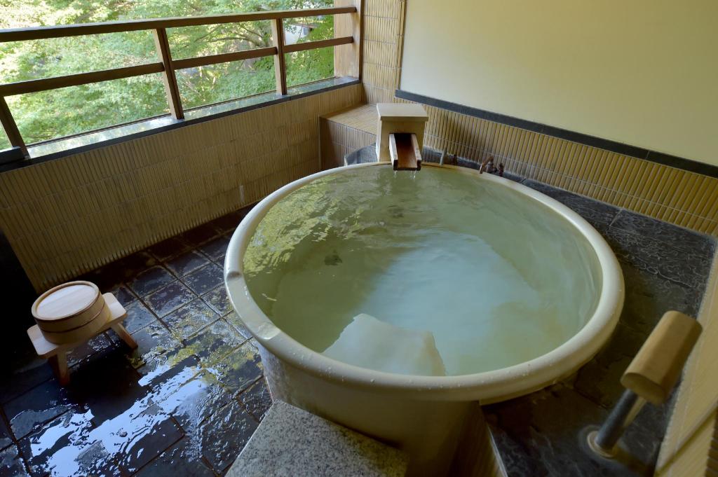 غرفة بسريرين منفصلين بمنطقة جلوس بحوض استحمام، Ryokan Sumiya Kihoan 2/4