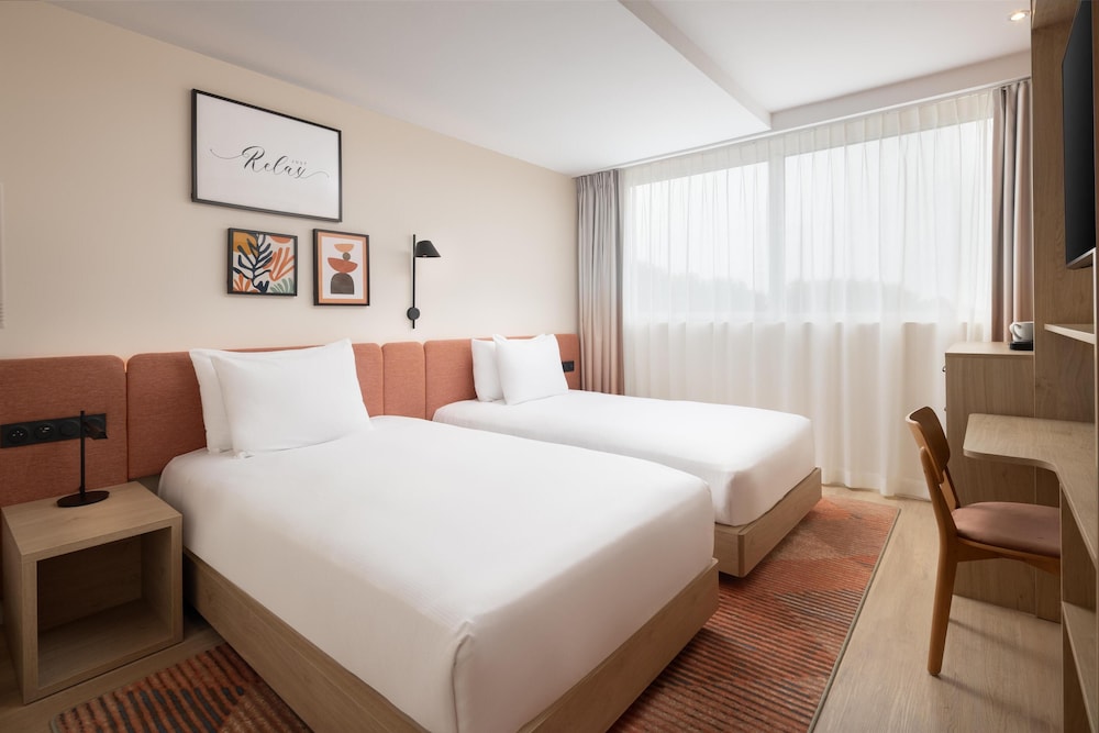 غرفة بسريرين منفصلين بحوض استحمام