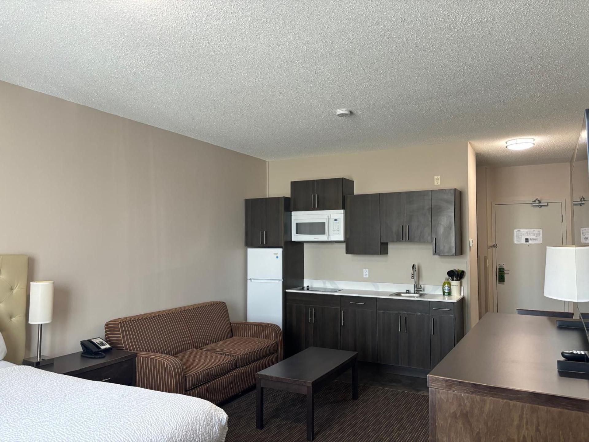 غرفة بسرير كوين مع أريكة بمطبخ صغير، Ramada by Wyndham Estevan 2/3