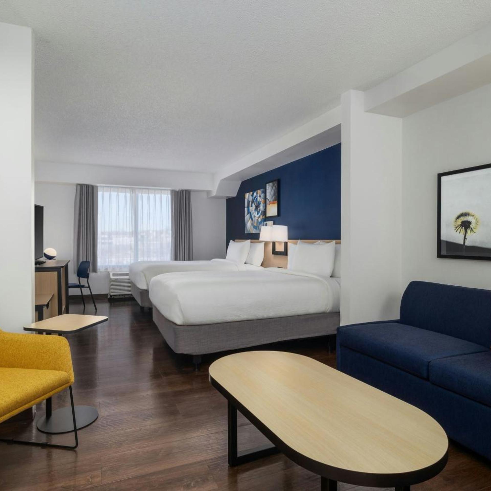 غرفة بسريرين كوين مع أريكة