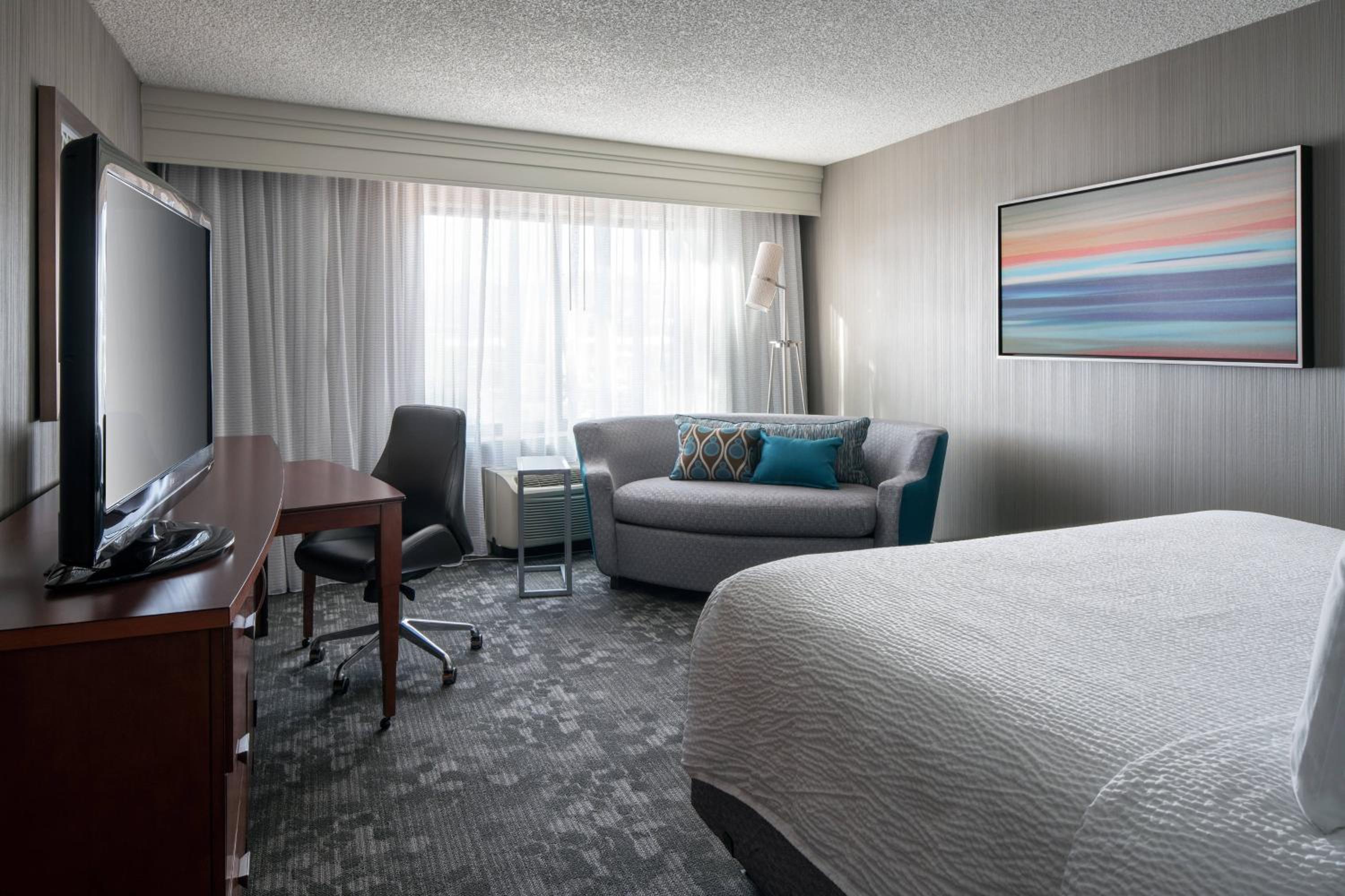 غرفة بسرير كينج مع أريكة بحوض استحمام لذوي الإعاقة