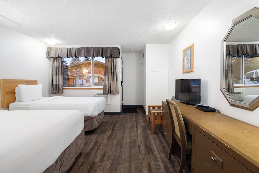 غرفة بسرير كوين وسرير فردي وسرير كوين بمطبخ