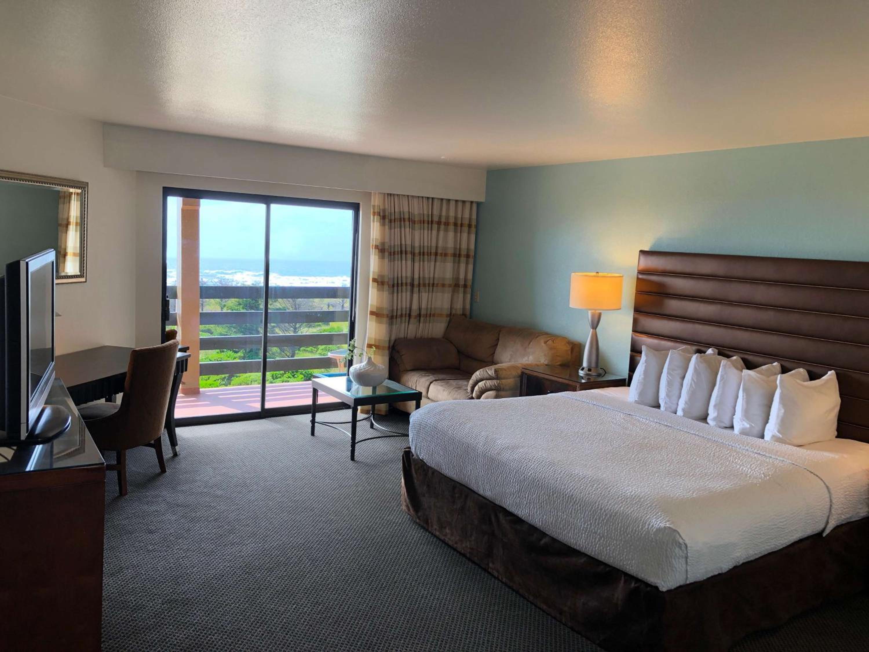 غرفة بسرير كينج بشرفة بإطلالة جزئية على البحر في طابق منخفض