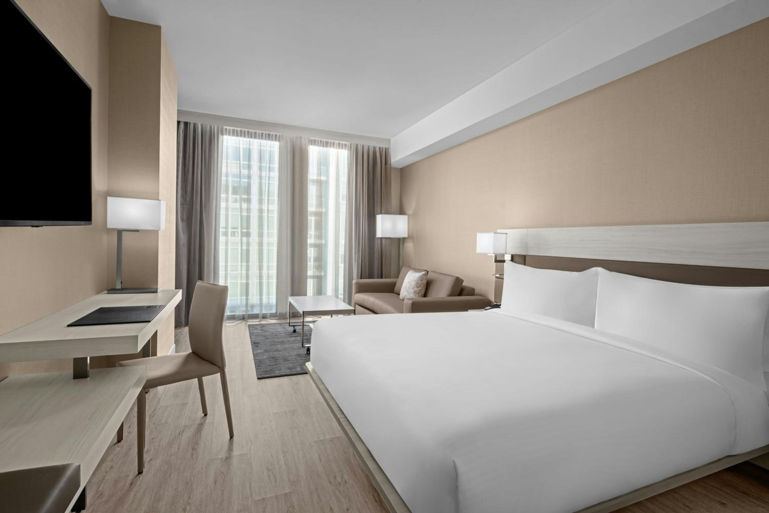 غرفة بسرير كينج مع أريكة بحوض استحمام لذوي الإعاقة