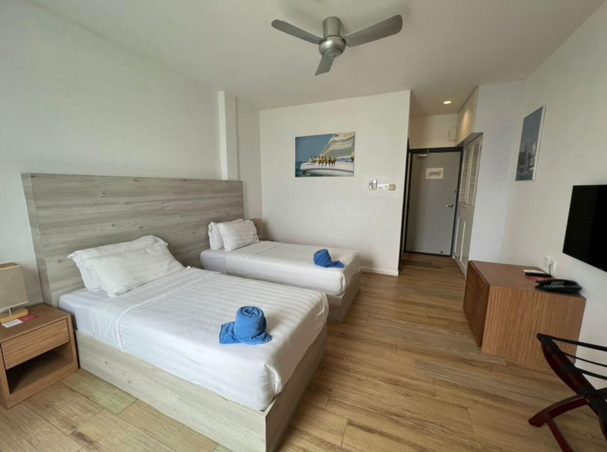 غرفة بسريرين منفصلين بإطلالة على البحر