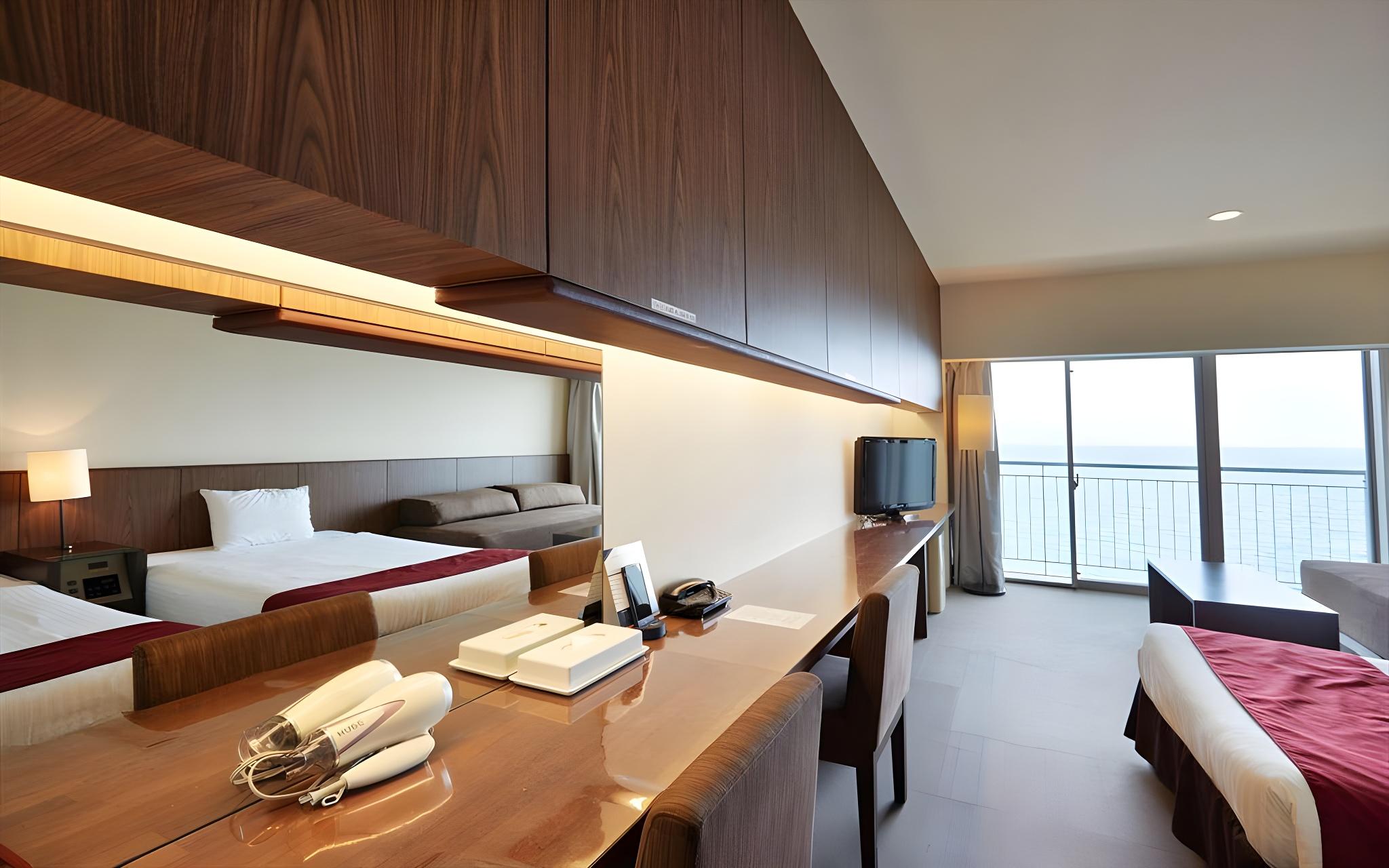 غرفة غربية بسريرين منفصلين بإطلالة على البحر مع أريكة