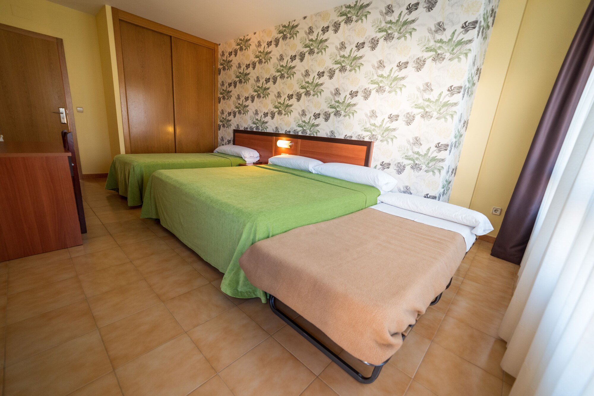غرفة ثلاثية بسرير كينج وسرير فردي بإطلالة على الحديقة